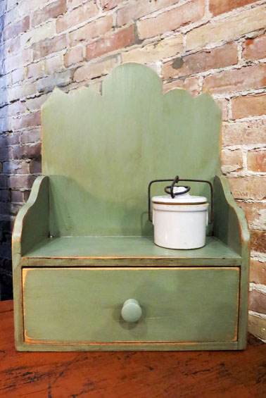 "Colonial Shelf" by John and Kaye. Their daughter sells their work online. She writes, "Love this little shelf/setter. Distressed sage green. Shelf measures 16 1/2"h x 12"w x 5 3/8"d. Sorry crock not included."